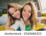 Two young women enjoying a cozy day indoors, capturing a joyful moment together