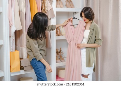 Two young women friends choosing a dress in a store or dressing room. Shopping, fashion and friendship concept. - Shutterstock ID 2181302361
