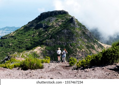 Two young women in front of the mountain. Pico Ruivo, October 2019. Madeira island, Portugal.