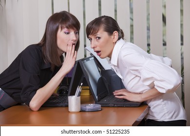 Two Young Women Gossip In A Office