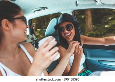 Two Young Women Hangout On Car Trip.They Are Driving The Car And Making Fun.Positive Emotions.