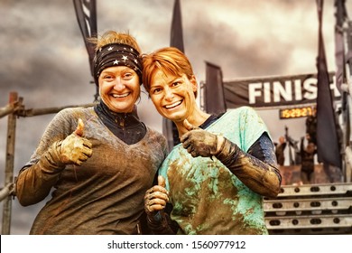 Two Young Women Having Finished a Mud Race Challenge - Powered by Shutterstock