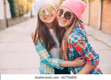 Two young women are hugging and laughing
