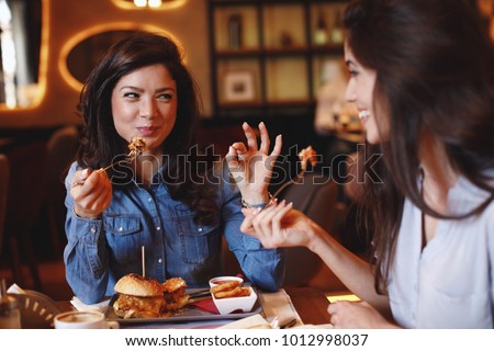 Two young women at a lunch in a restaurant