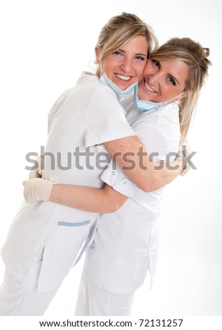 Two young women in medical attire hugging