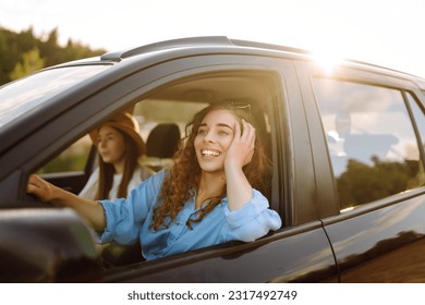 Two young women on car trip having fun. Lifestyle, travel, tourism, nature, active life. - Powered by Shutterstock