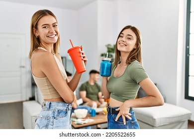 Two Young Women On Party Smiling Happy And Drinking Soda At Home.