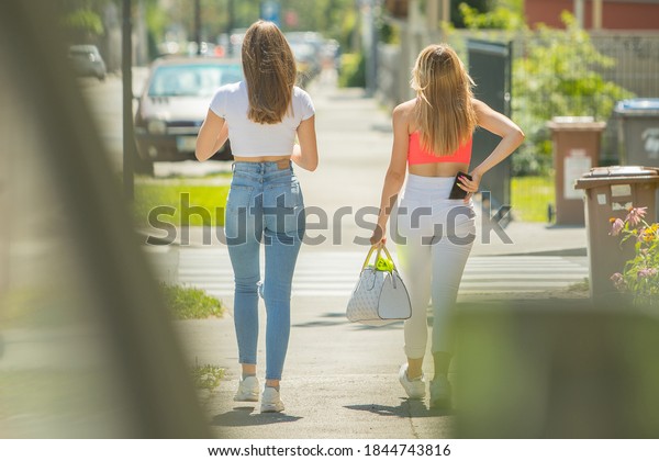 Blonde girlfriends with beatiful asses walking on the street
