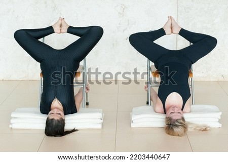 Two young women practicing yoga. Yoga pose, outdoor, indoor