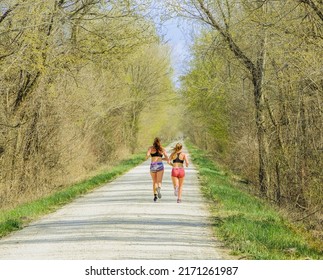 Two Young Women Running On Trail In Missouri State Park Early In The Spring