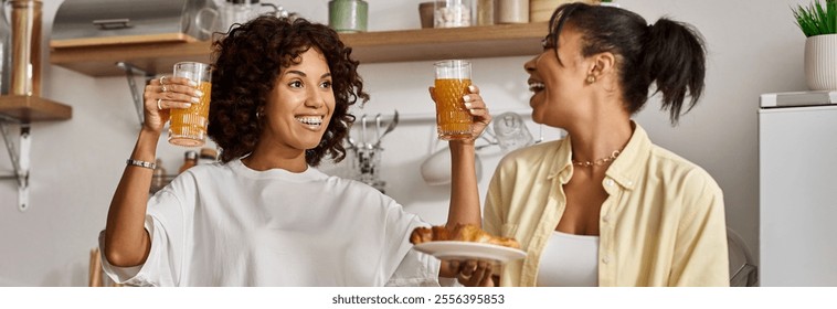 Two young women share laughter and love over breakfast in their cozy kitchen, banner - Powered by Shutterstock