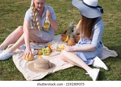 A Two Young Women In A Similar Blue Dress Is Resting On A Picnic, Chees Plate