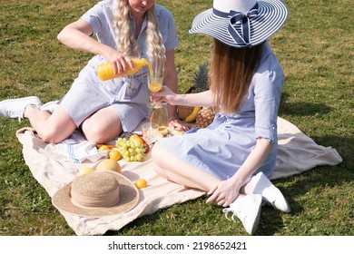 A Two Young Women In A Similar Blue Dress Is Resting On A Picnic, Chees Plate