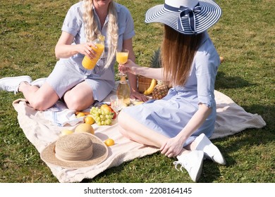 A Two Young Women In A Similar Blue Dress Is Resting On A Picnic, Chees Plate