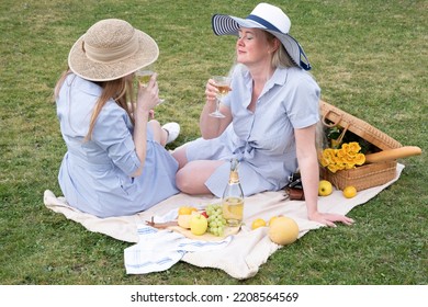 A Two Young Women In A Similar Blue Dress Is Resting On A Picnic, Chees Plate