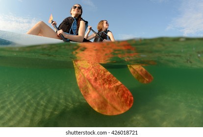 Two Young Women Smiling In Kayak Off Of The Coast Of Florida