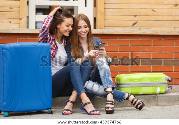 Two young women with\
suitcases. Vacation concept. Car trip. Summer vacation. Best friend\
posing with their luggage. women traveling with suitcases, walking\
on the road