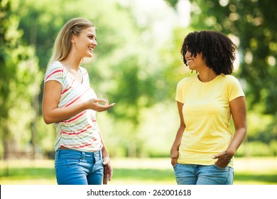 Two Young Women Talking In Park