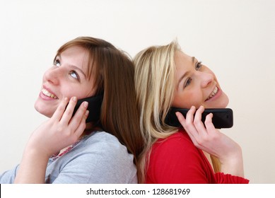 Two Young Women Talking Together On Cell Phone.