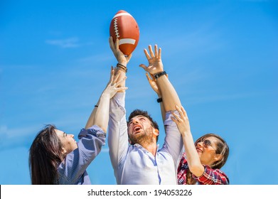 Two young women trying to catch an american football ball - Powered by Shutterstock