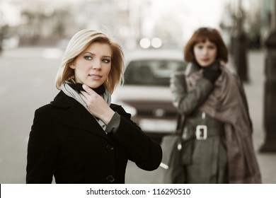 Two Young Women Walking On The City Street