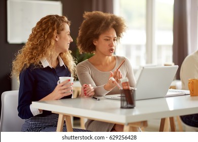 Two young women working on the laptop - Shutterstock ID 629256428