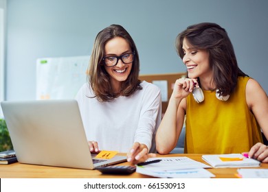 Two Young Women Working Together At Startup Office Planning New Business