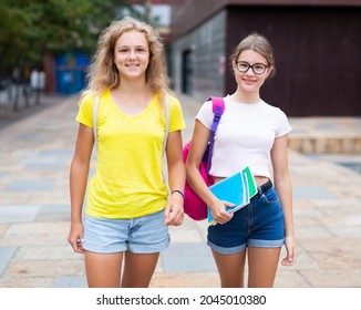 Two youth girls with backbacks going to school together.
