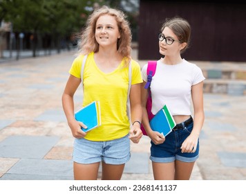Two youth girls with backbacks going to school together.