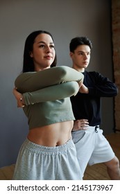 Two youthful stylish animator dancers in activewear performing vogue dance in studio or training new movements during repetition
