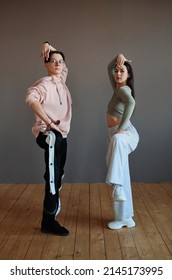 Two youthful vogue dancers in activewear keeping their legs bent in knee while working over new movements during training in studio