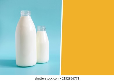 Two-color layout with two glass bottles of natural milk. One liter and 0.5 liters of milk in glass bottles on an orange-blue background place for text