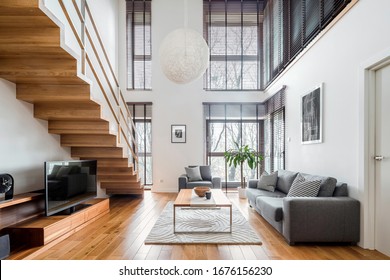 Two-floor apartment with spacious living room with wooden stairs, hardwood floor and many, big windows - Powered by Shutterstock