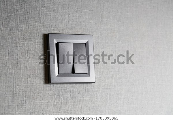 Two-key switch\
gray on the wall a plastic mechanical switch. Light switch\
installed after repair. The concept of energy savings. Closeup of\
Light Switch with copy space to the\
side