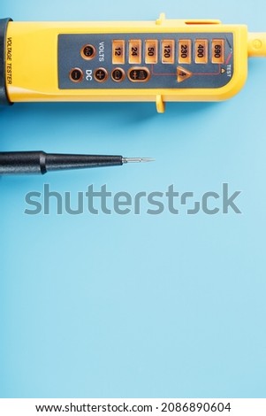 Two-pole voltage indicator close-up on a blue background. Testing and verification of electrical networks