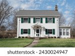 Two-story, white Colonial-style house with green shutters.