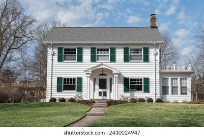 Two-story, white Colonial-style house with green shutters. - Powered by Shutterstock