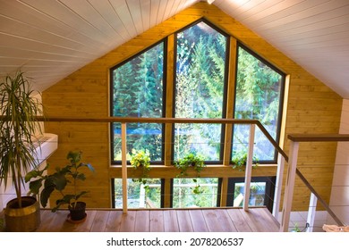 A Two-story Wooden Cottage From The Inside Out In Coniferous Spruce Pine Green Forest. Amazing Heartbreaking View From The Panoramic Large Window Of A Summer Country House. Modern Living Room Indoors