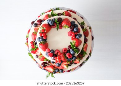 Two-tiered Wedding Cake In Chocolate, With Slices Strawberries, Raspberries, Blackberry On A White Background. Top View