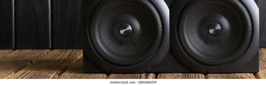 A two-way mid-range speaker system installed in a natural pine interior. Eco style. Web banner. Close-up