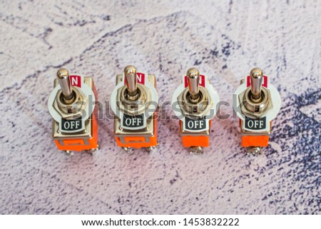 Two-way orange toggle switch on a concrete background.