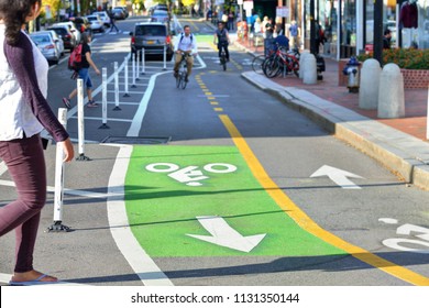 Two-way protected bike lanes with pavement markers, striped median, buffer zone and flexible delineators in city street - Shutterstock ID 1131350144