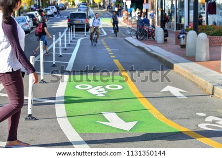 Two-way protected bike lanes with pavement markers, striped median, buffer zone and flexible delineators in city street