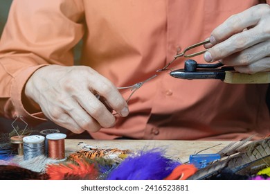 Tying a fly fishing fly. A set of various accessories and materials for tying fly fishing lures. Close-up. - Powered by Shutterstock