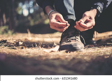 Tying The Hiking Boots Of A Hiker In The Forset On Mountian.