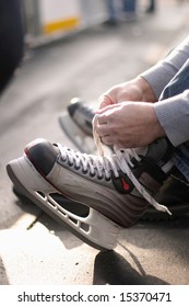 Tying Laces Of Ice Hockey Skates At Skating Rink