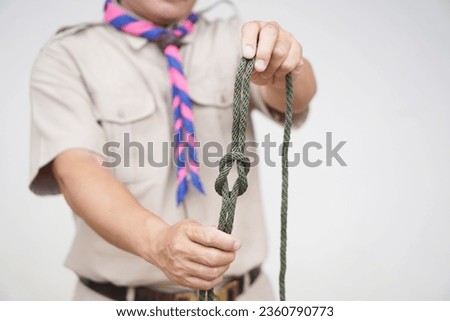 Tying rope knot pattern, demonstrated by scout teacher trainer. Concept, useful tying knot for many purposes in daily life. Tying knot rope teaching aid. Life skills with rope.                        