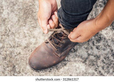 Tying Shoes On Cement Floor