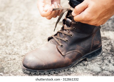 Tying Shoes On Cement Floor