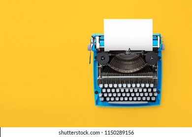 Typewriter machine in retro style on yellow background. Top view.